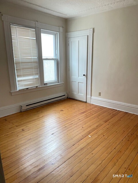 281 Chestnut Street New Britain, CT 06051 - Photo 10 of 18 a view of an empty room with wooden floor and a window