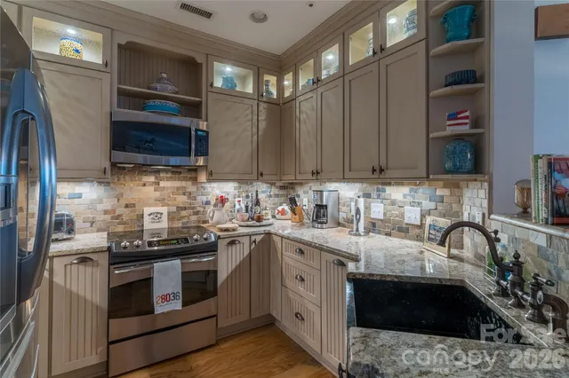 a kitchen with stainless steel appliances a stove sink microwave and cabinets