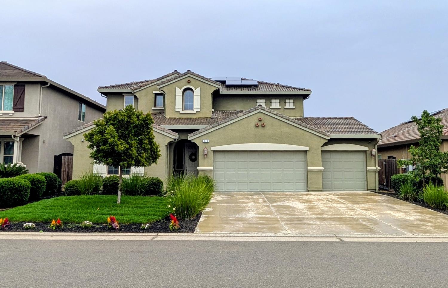 a front view of a house with a yard and potted plants