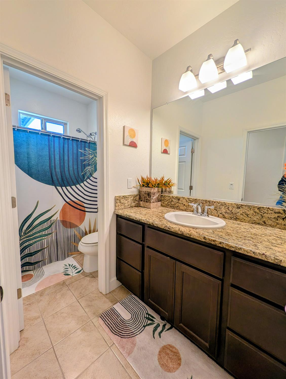 174 Emperor Way Dinuba, CA 93618 - Photo 13 of 23 a bathroom with a sink a toilet and a mirror
