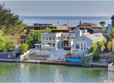 a view of a lake with a building and a lawn chairs