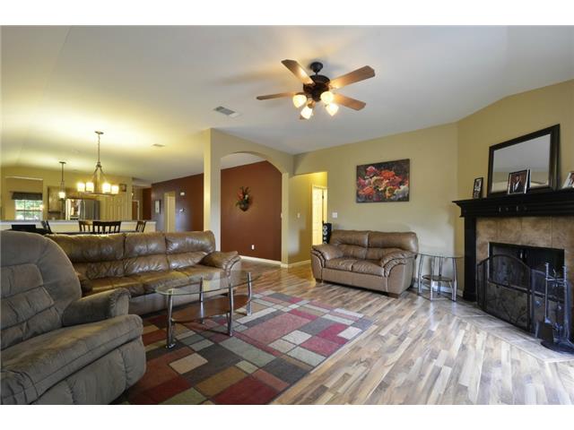 11612 Timber Heights Drive Austin, TX 78754 - Photo 6 of 28 A welcoming living area boasts durable flooring, an inviting fireplace, and an elegant ceiling fan.