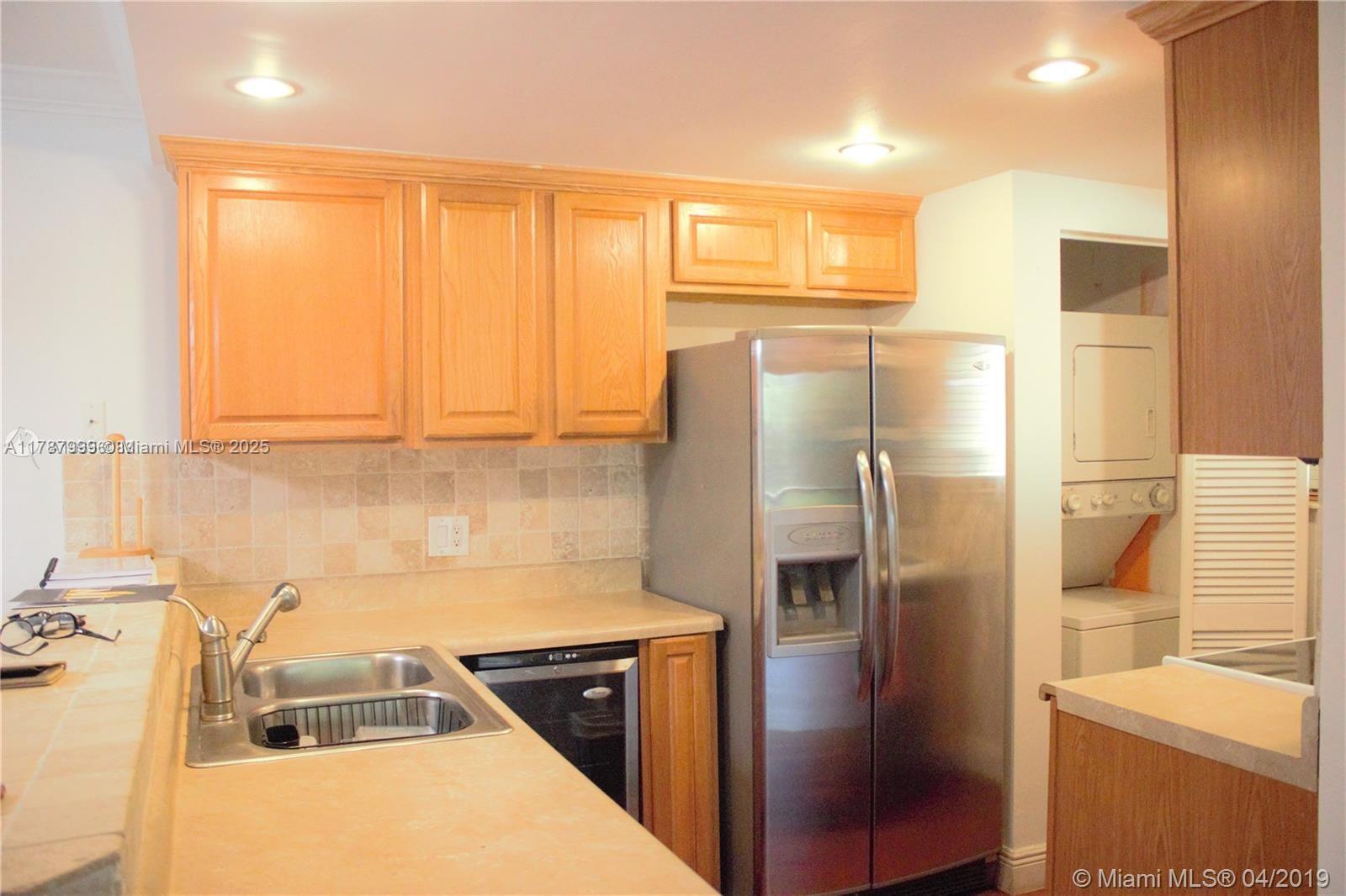 545 Trace Circle, Unit 110 Deerfield Beach, FL 33441 - Photo 3 of 20 a kitchen with a refrigerator and a sink
