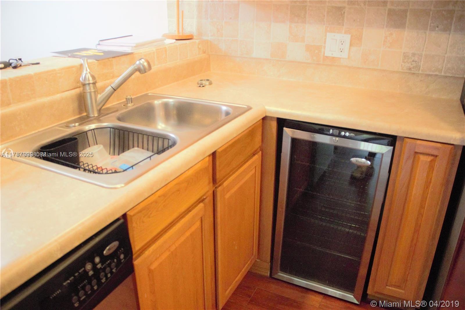 545 Trace Circle, Unit 110 Deerfield Beach, FL 33441 - Photo 5 of 20 a kitchen with a sink and washing machine