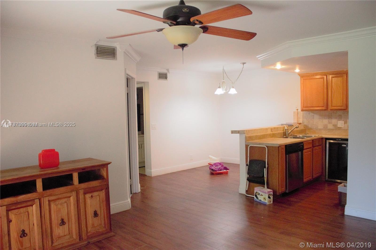 545 Trace Circle, Unit 110 Deerfield Beach, FL 33441 - Photo 8 of 20 a view of a room with wooden floor and ceiling fan