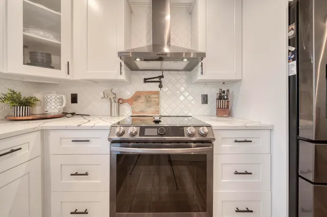 a kitchen with white cabinets and stainless steel appliances