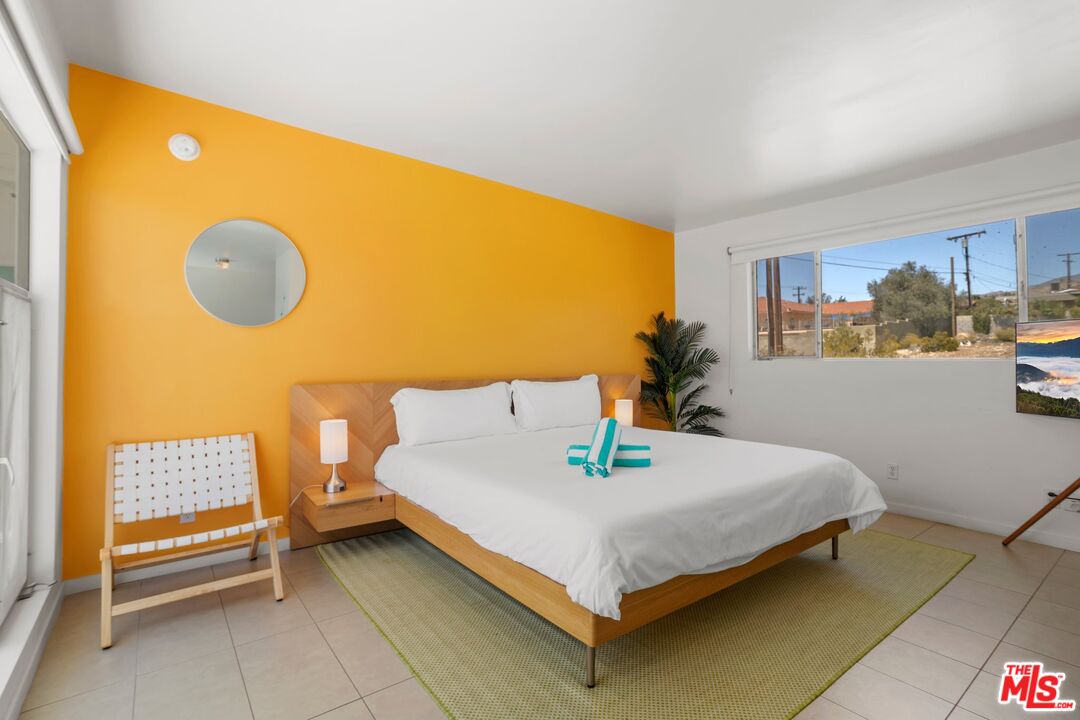 12689 Eliseo Road Desert Hot Springs, CA 92240 - Photo 11 of 28 a bedroom with a bed and a painting on the wall