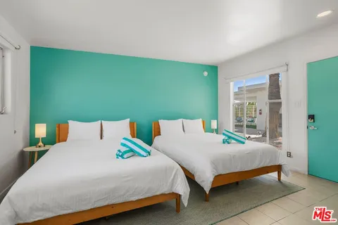 a bed sitting in a room next to a larger window