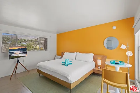 a bedroom with a bed and a potted plant