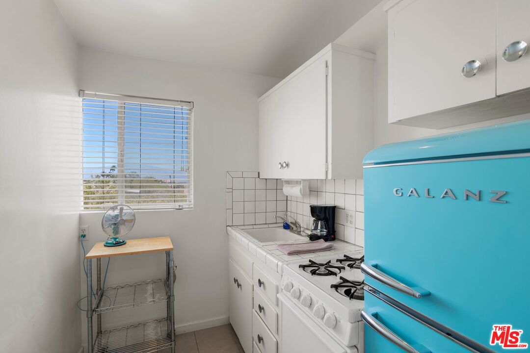 12689 Eliseo Road Desert Hot Springs, CA 92240 - Photo 22 of 28 a kitchen with a sink a stove and cabinets