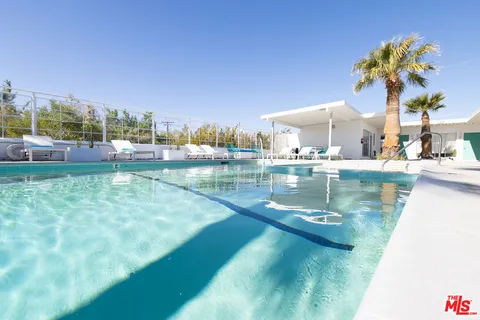 a view of a house with swimming pool and sitting area