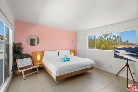 a bedroom with a bed and a painting on the wall