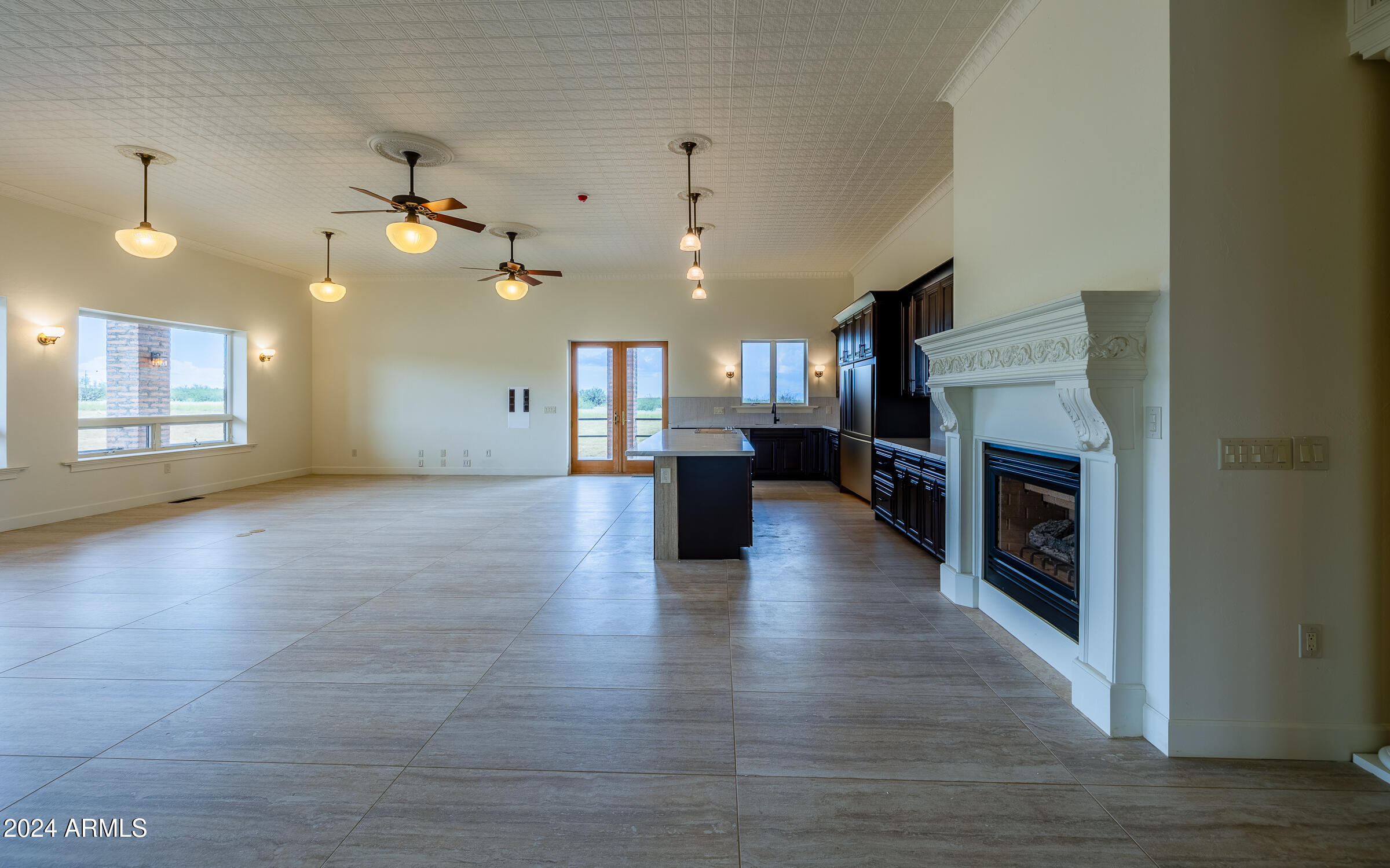 a view of a kitchen and an empty room with a fireplace