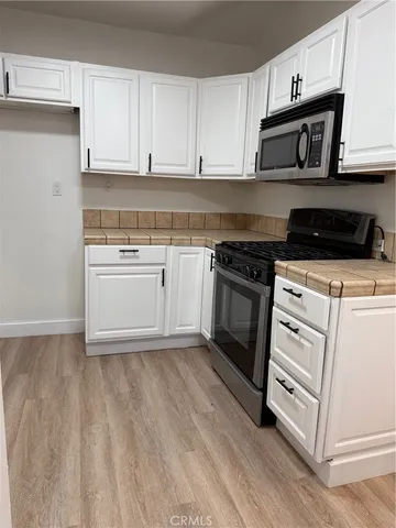 a kitchen with white cabinets and appliances