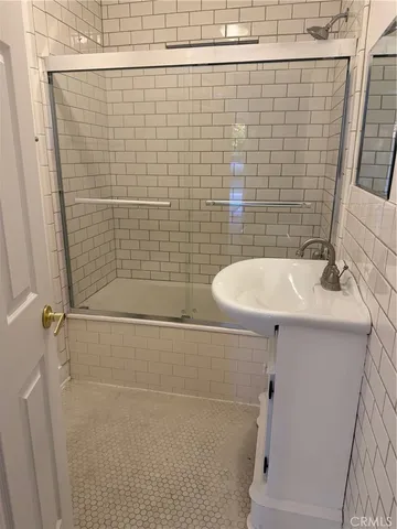 a bathroom with a sink a mirror and shower