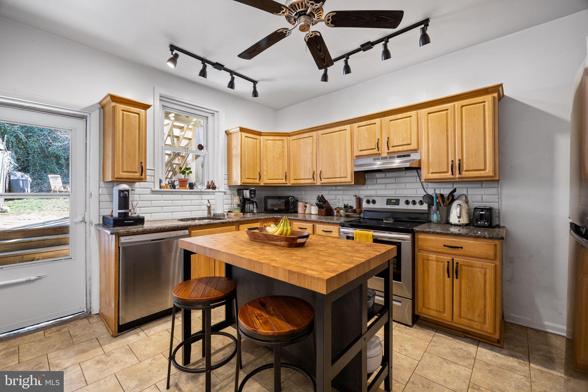 3743 Sharp Street Philadelphia, PA 19127 - Photo 4 of 25 a kitchen with a stove a sink dishwasher a refrigerator and a dining table with wooden floor