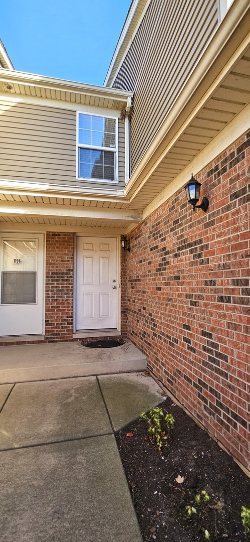 1196 Meagan Court Elgin, IL 60120 - Photo 2 of 26 a front view of a house with a yard