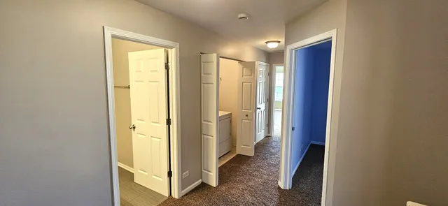 a view of a hallway with closet and wooden floor