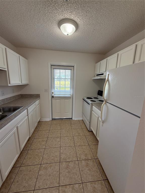 2744 Botts Landing Road, Unit 204 DeLand, FL 32720 - Photo 5 of 19 a kitchen with a refrigerator a stove top oven and cabinets
