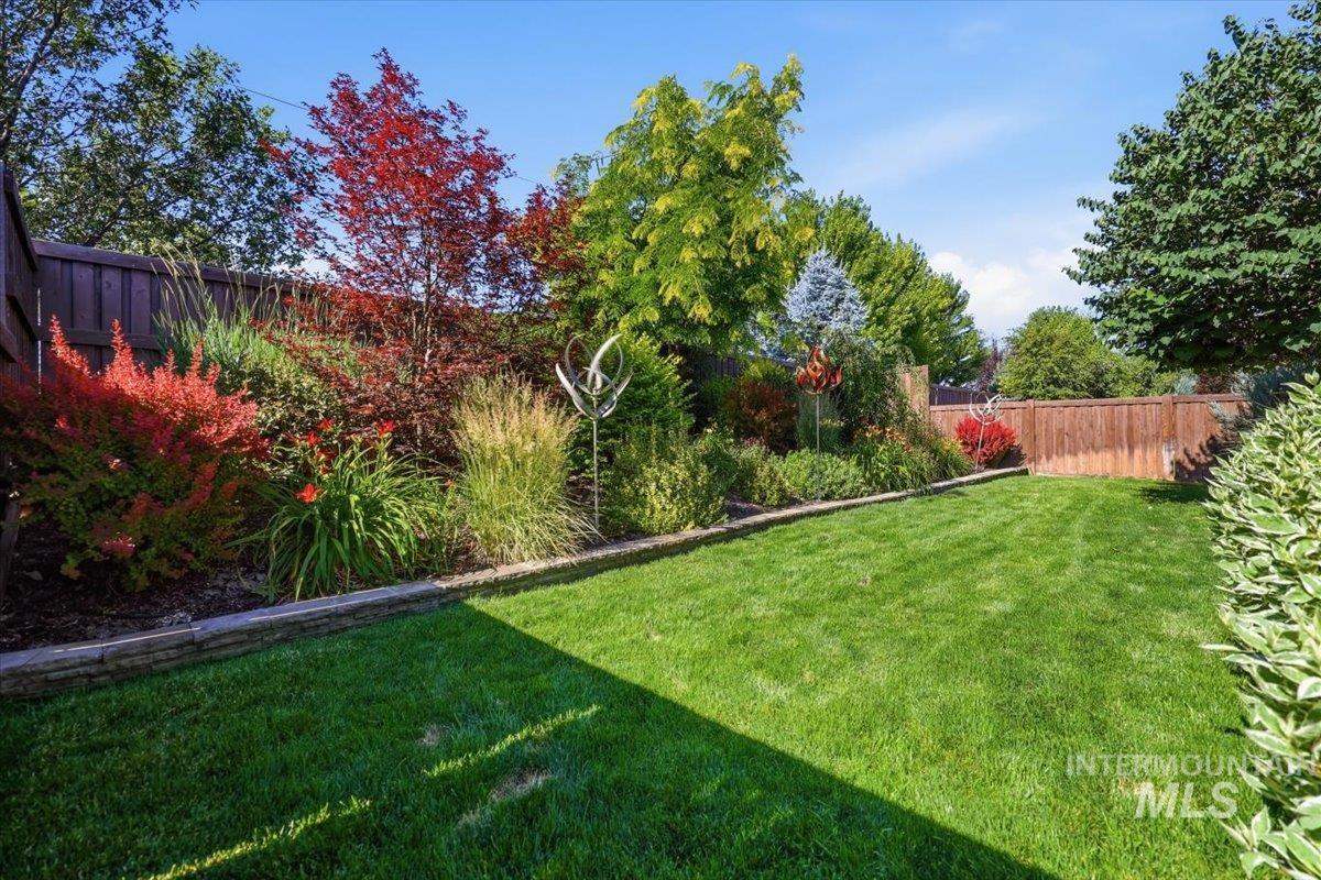 1303 West Brando Street Meridian, ID 83646 - Photo 38 of 49 Generous green lawn bordered by a stone retaining wall and mature landscaping