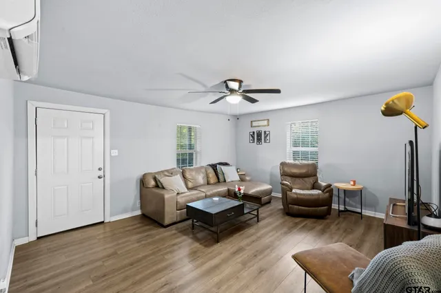 a living room with furniture and a wooden floor