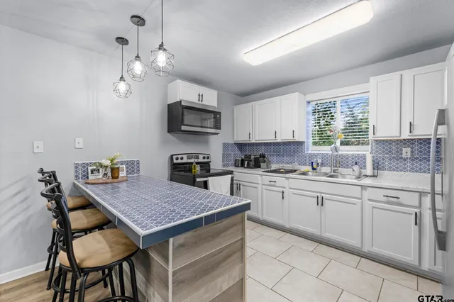 a kitchen with kitchen island granite countertop a sink counter space and stainless steel appliances