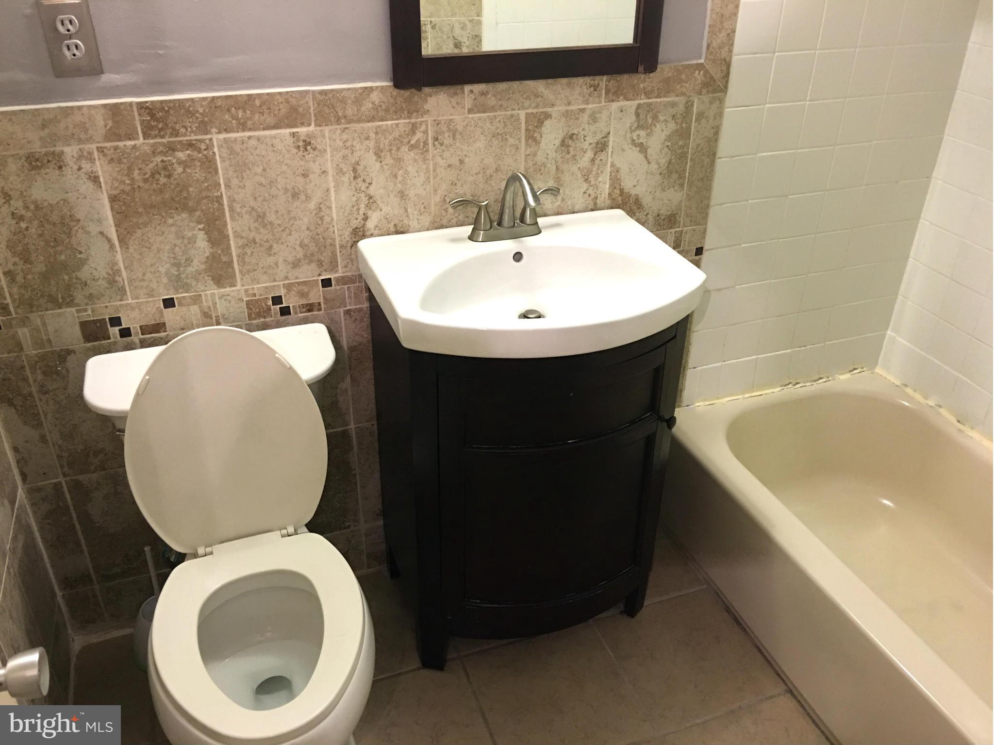 9270 Adelphi Road, Unit 103 Hyattsville, MD 20783 - Photo 11 of 14 a bathroom with a sink a toilet and bathtub
