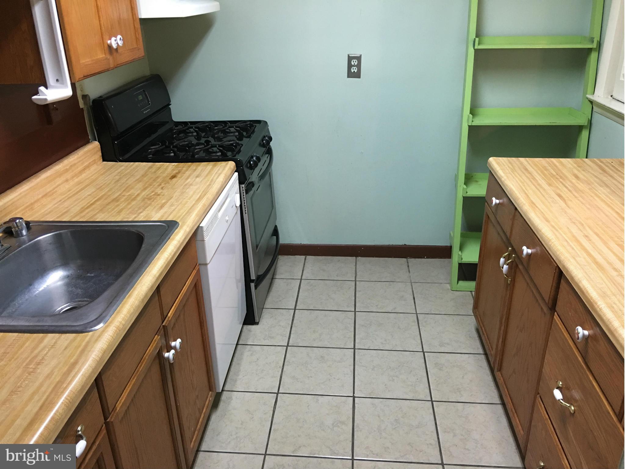 9270 Adelphi Road, Unit 103 Hyattsville, MD 20783 - Photo 6 of 14 a kitchen with a stove and a cabinets