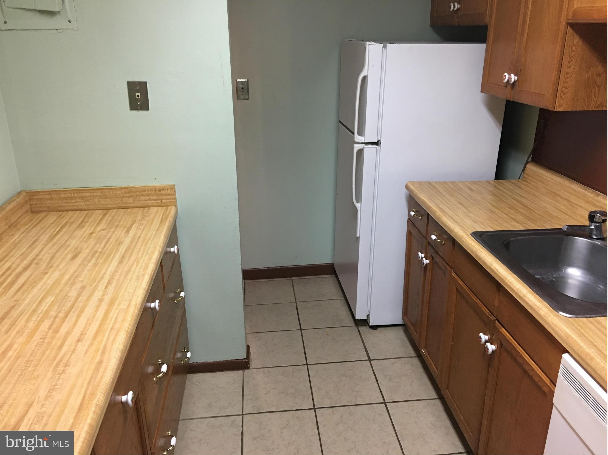 9270 Adelphi Road, Unit 103 Hyattsville, MD 20783 - Photo 7 of 14 a kitchen with a refrigerator and a stove