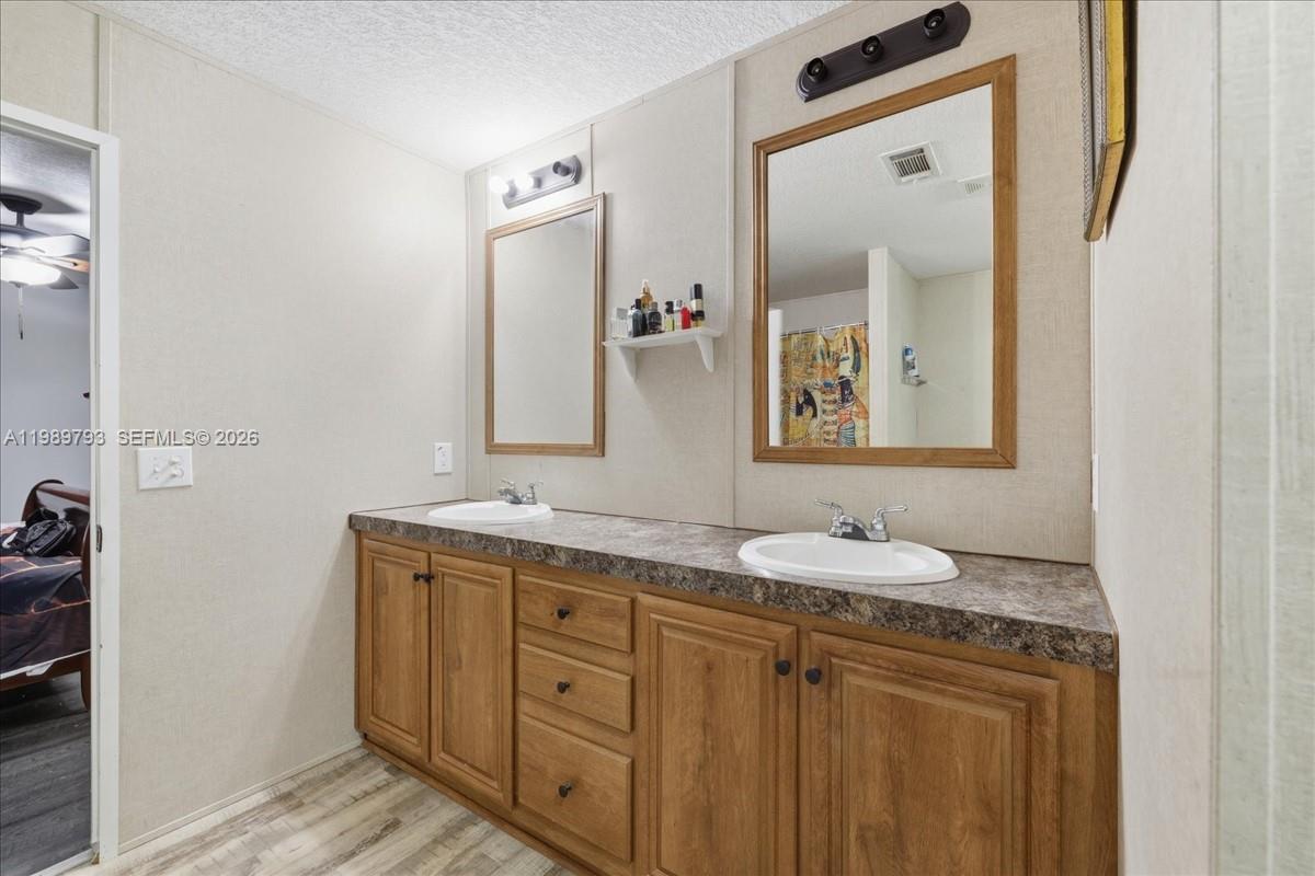 415 South Kennel Street Clewiston, FL 33440 - Photo 13 of 34 a bathroom with a granite countertop sink vanity and mirror