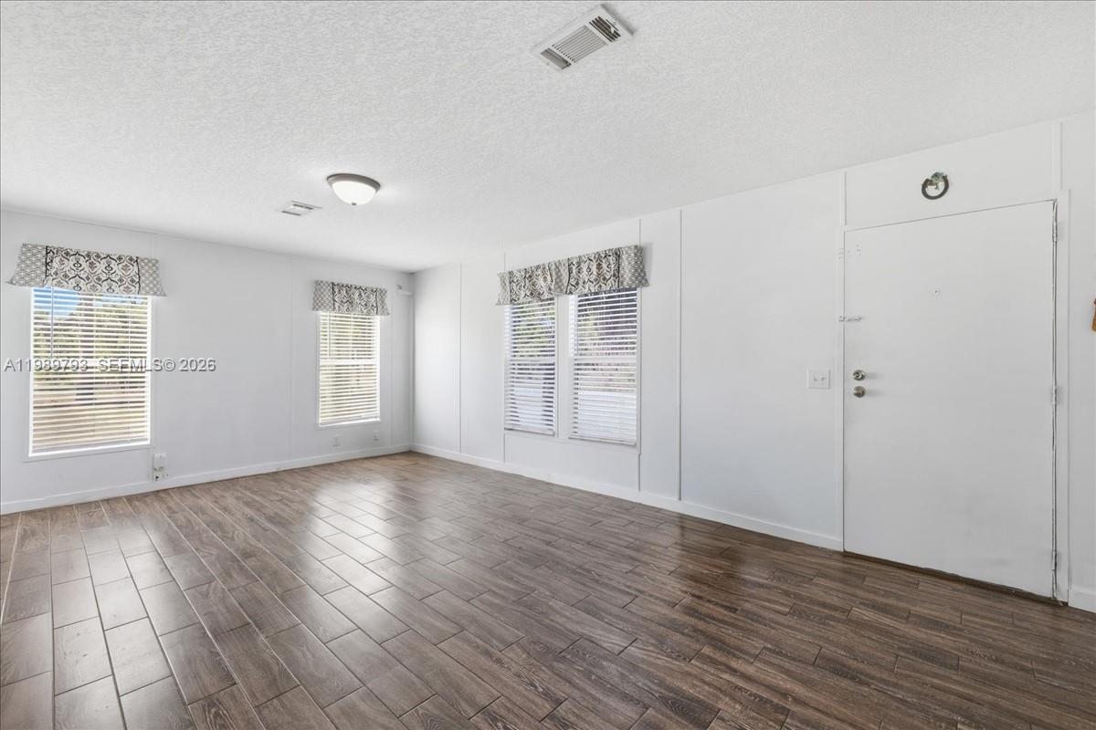 415 South Kennel Street Clewiston, FL 33440 - Photo 2 of 34 a view of an empty room with wooden floor and a window