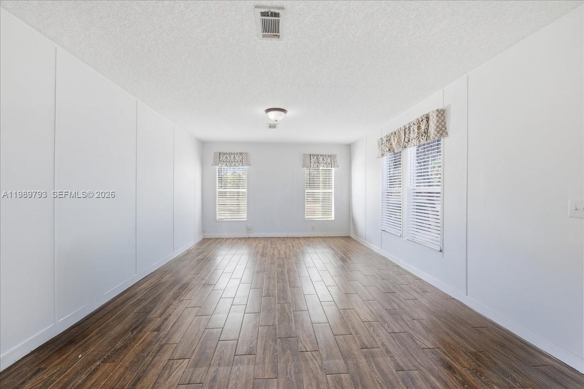 415 South Kennel Street Clewiston, FL 33440 - Photo 4 of 34 a view of an empty room with wooden floor and a window