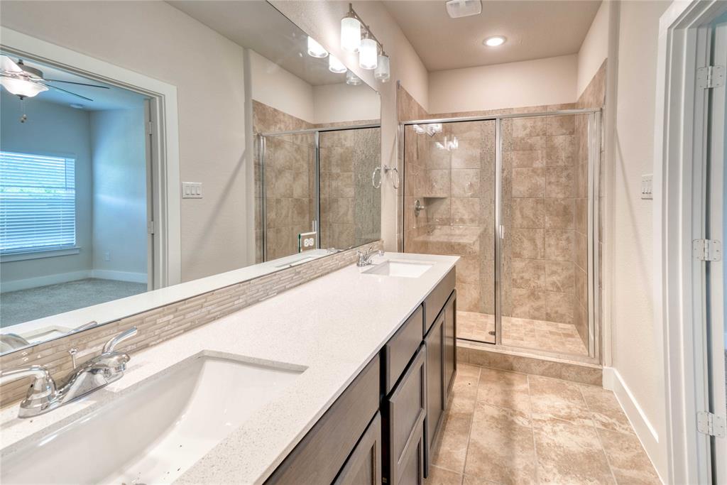 1407 Apricot Lane Gainesville, TX 76240 - Photo 8 of 9 a spacious bathroom with a granite countertop sink a shower and a mirror