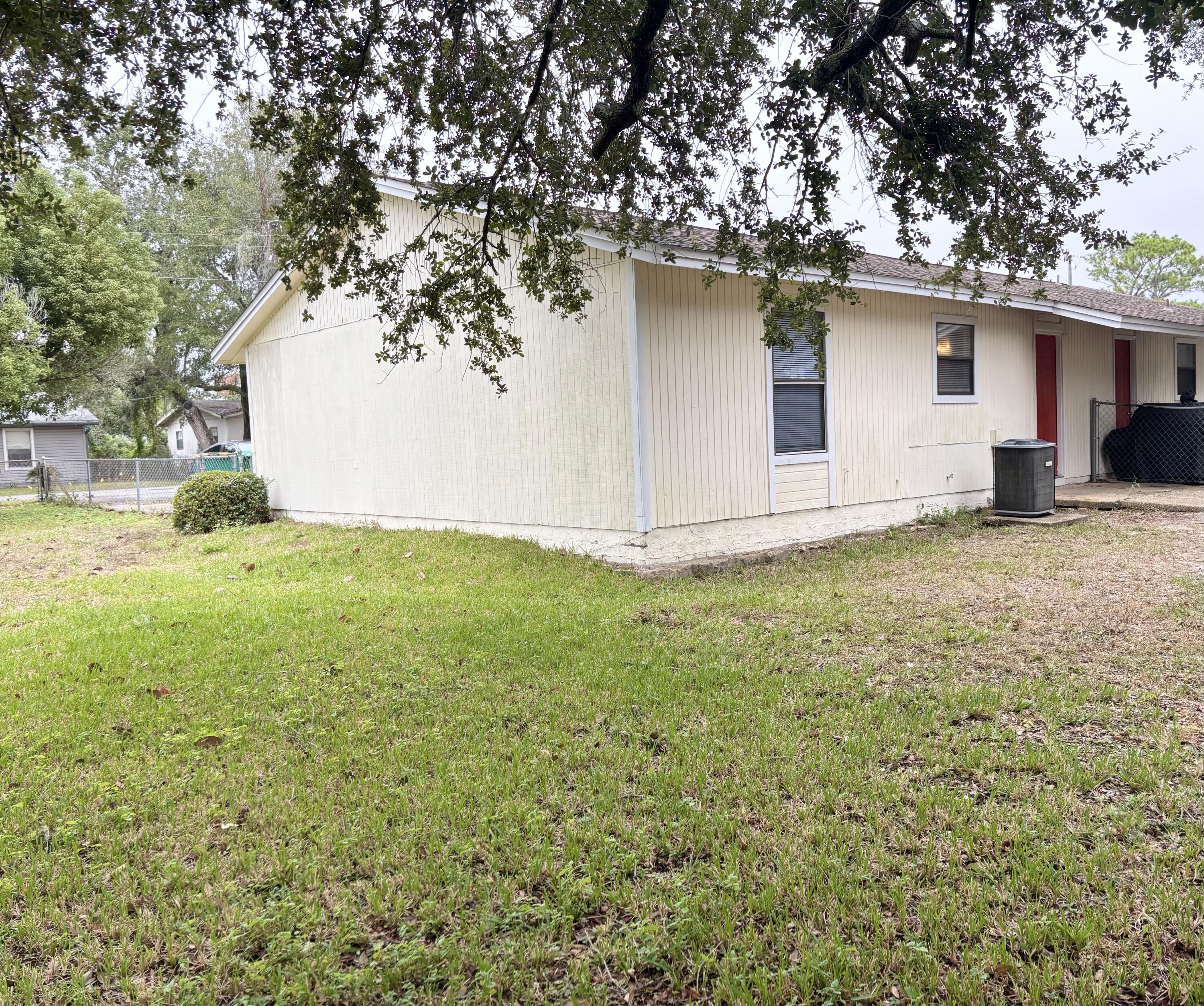 208 Squirrel Haven Road, Unit A Mary Esther, FL 32569 - Photo 11 of 13 a backyard of a house with yard and garage