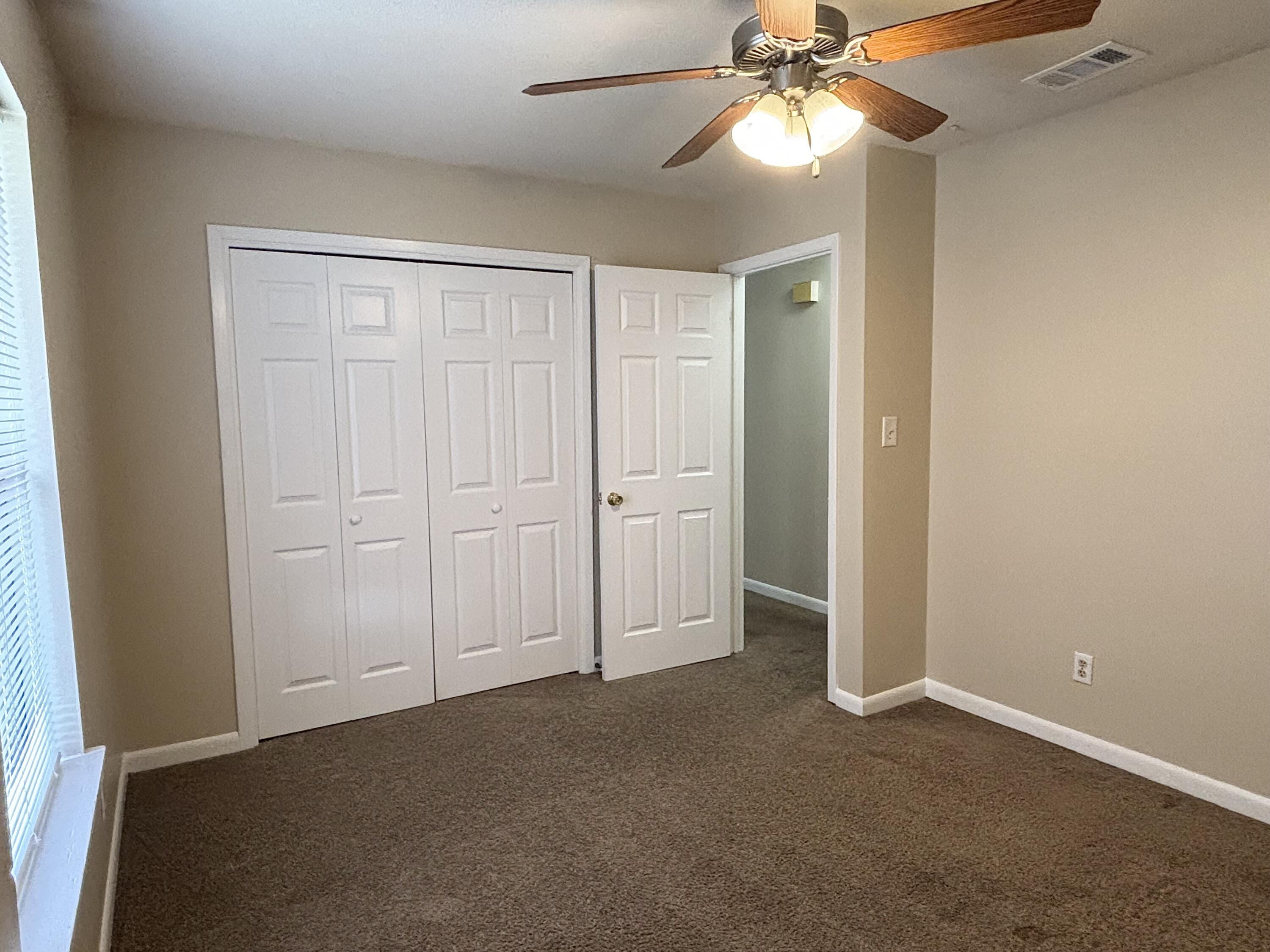 208 Squirrel Haven Road, Unit A Mary Esther, FL 32569 - Photo 4 of 13 an empty room with closet and a chandelier fan