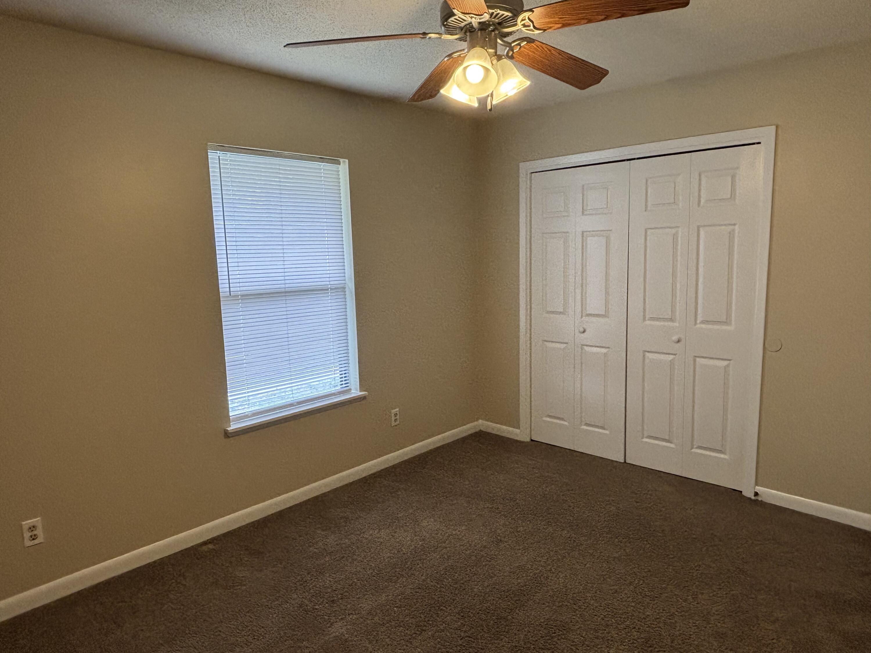 208 Squirrel Haven Road, Unit A Mary Esther, FL 32569 - Photo 5 of 13 an empty room with windows and fan