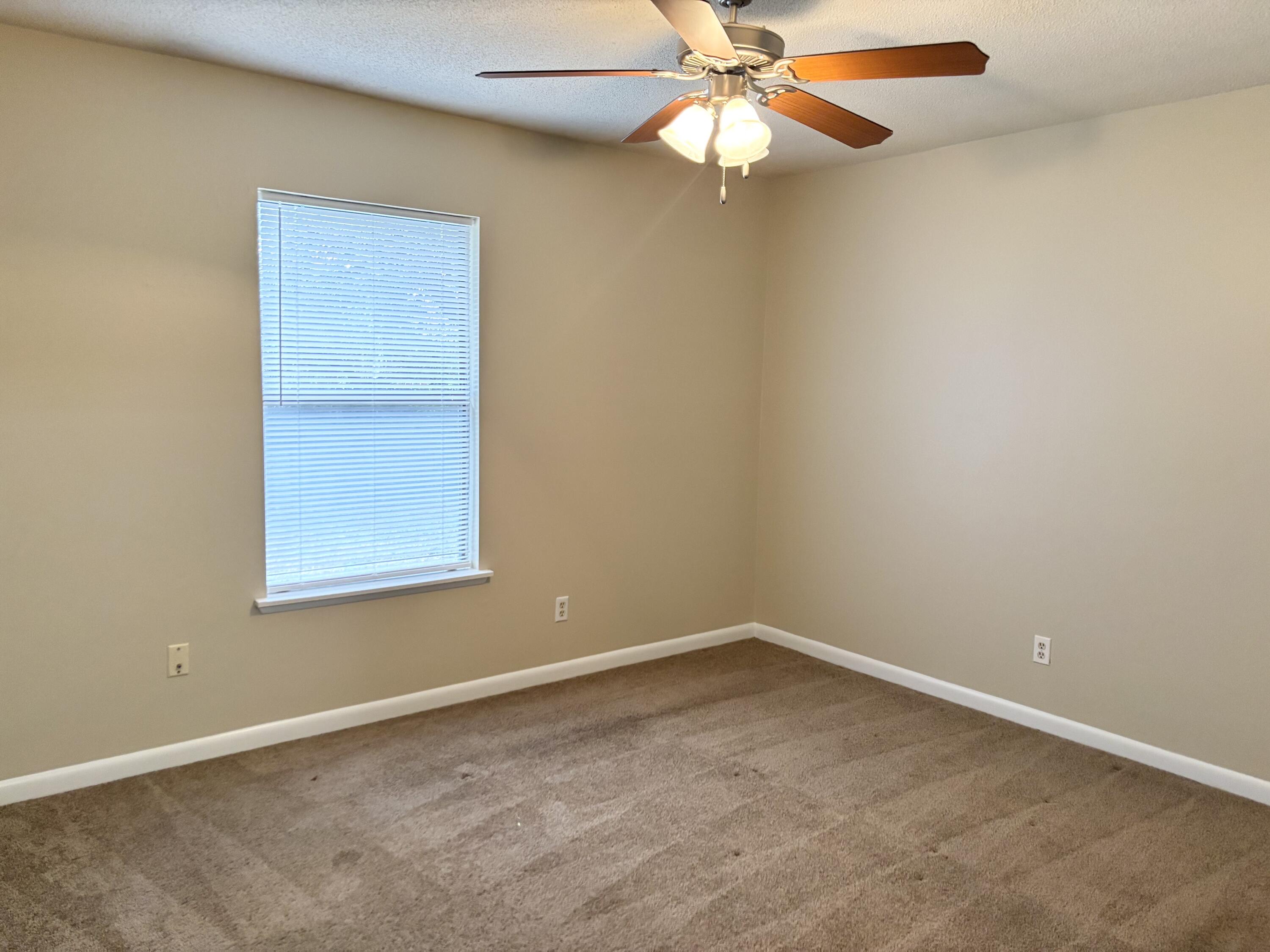 208 Squirrel Haven Road, Unit A Mary Esther, FL 32569 - Photo 7 of 13 an empty room with a window and chandelier fan