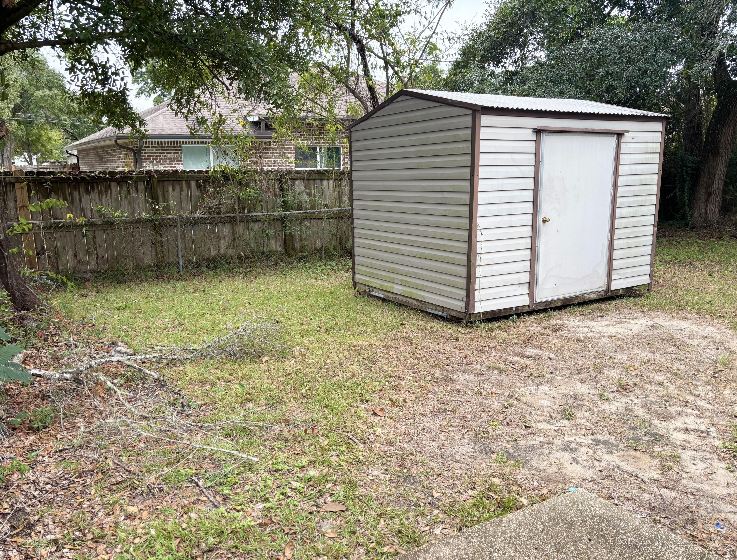 208 Squirrel Haven Road, Unit A Mary Esther, FL 32569 - Photo 10 of 13 a view of a small house with a yard and wooden fence