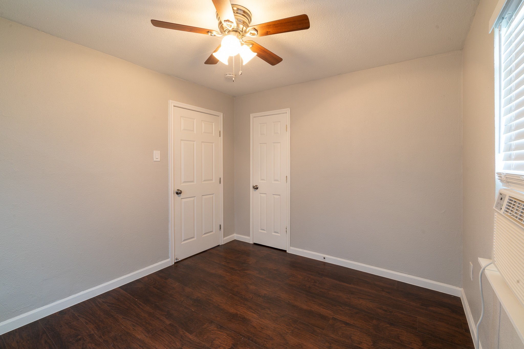 2507 Delano Street, Unit 4 Houston, TX 77004 - Photo 8 of 12 an empty room with wooden floor and windows