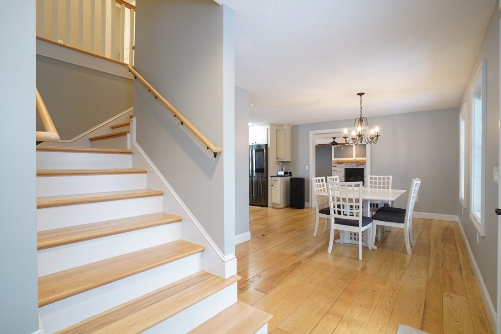 162 Fiskdale Road Brookfield, MA 01506 - Photo 18 of 42 a dining room with wooden floor a chandelier a glass table and chairs