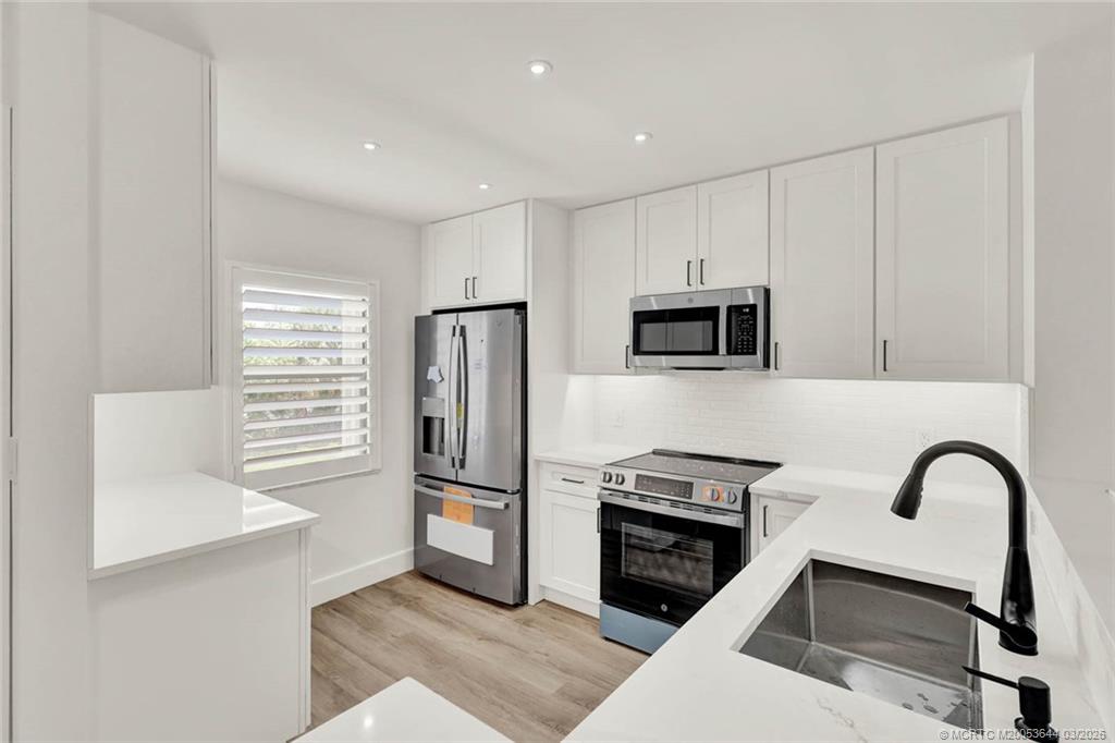 1950 Southwest Palm City Road, Unit 3201 Stuart, FL 34994 - Photo 3 of 27 a kitchen with a refrigerator and a stove top oven
