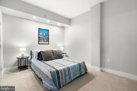 a bedroom with a bed and a painting on the wall
