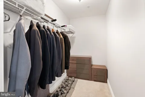 a view of walk in closet with clothes and shoes