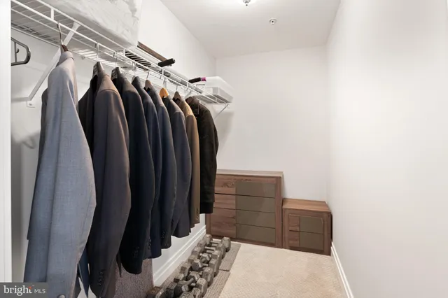 a view of walk in closet with clothes and shoes