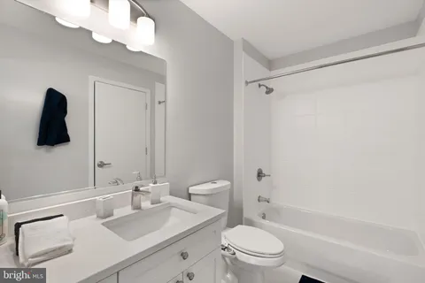 a bathroom with a granite countertop sink a toilet and shower