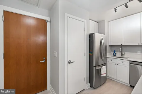 a view of a refrigerator in kitchen and a sink