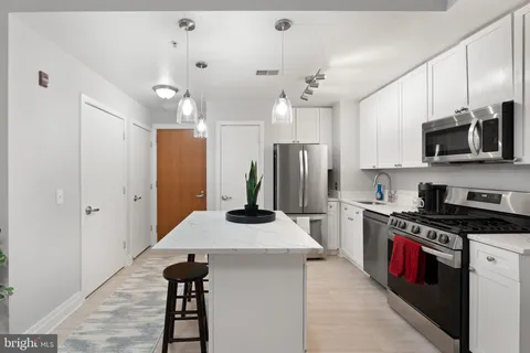 a kitchen with kitchen island a sink appliances and cabinets