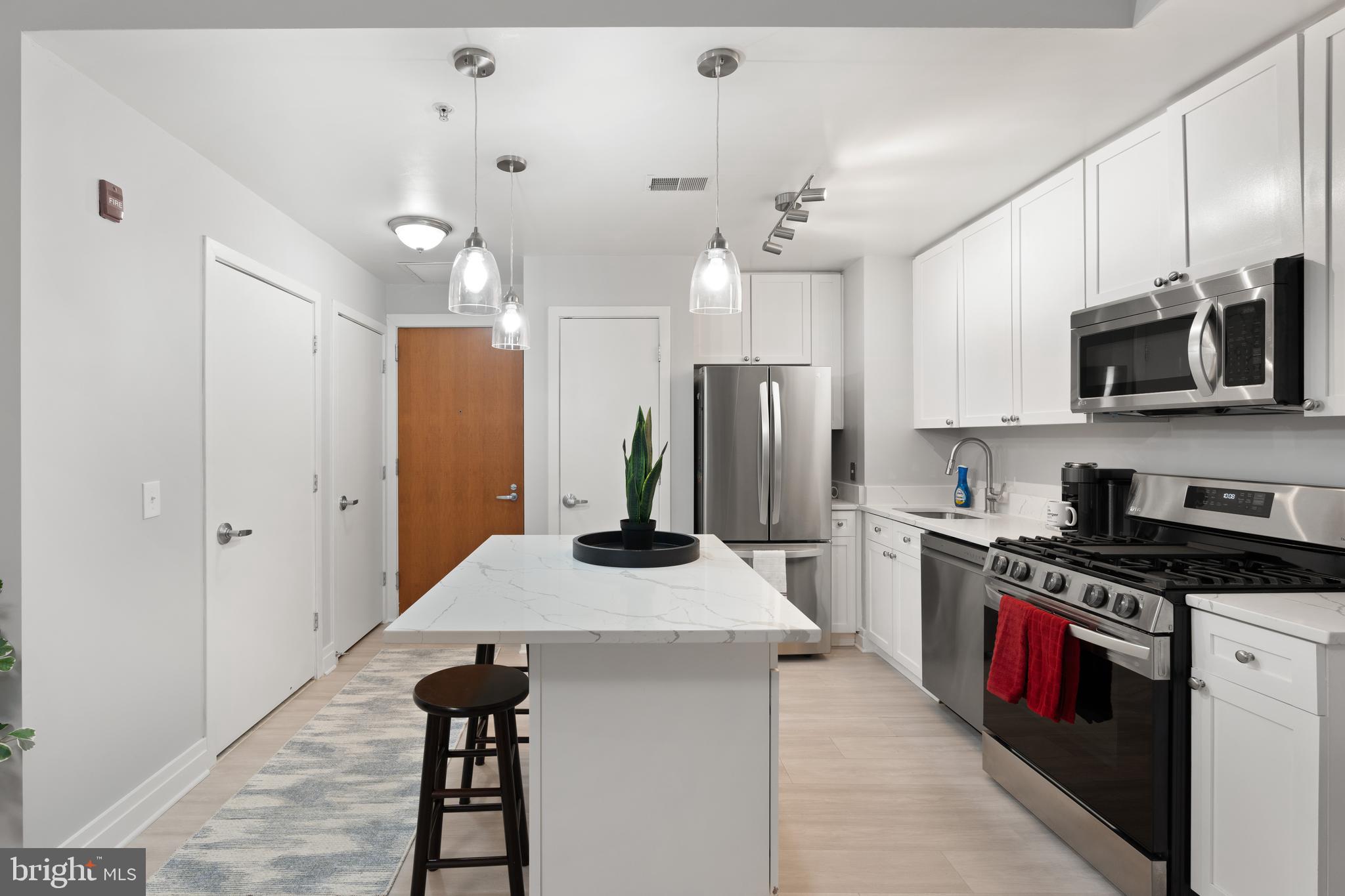 2120 Vermont Avenue Northwest, Unit 17 Washington, DC 20001 - Photo 5 of 35 a kitchen with kitchen island a sink appliances and cabinets