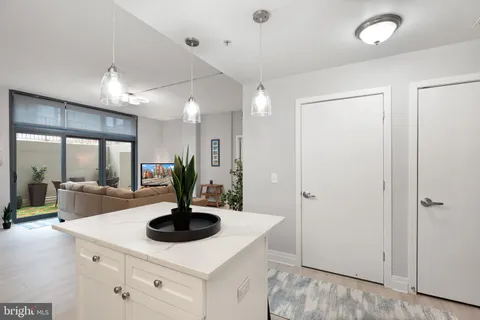 a view of living room with granite countertop a sink a fireplace and cabinets