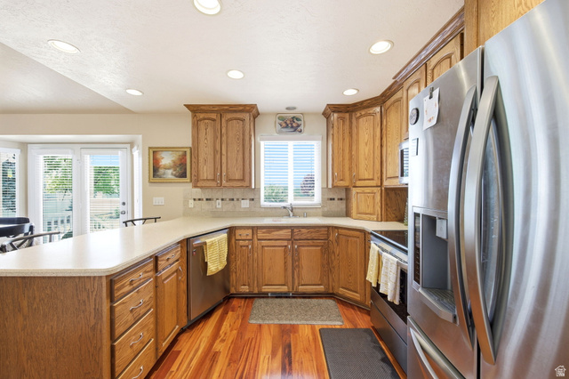 776 Flint Street Layton, UT 84041 - Photo 5 of 41 Kitchen featuring wood-finish flooring, light-toned countertops, and wood cabinetry